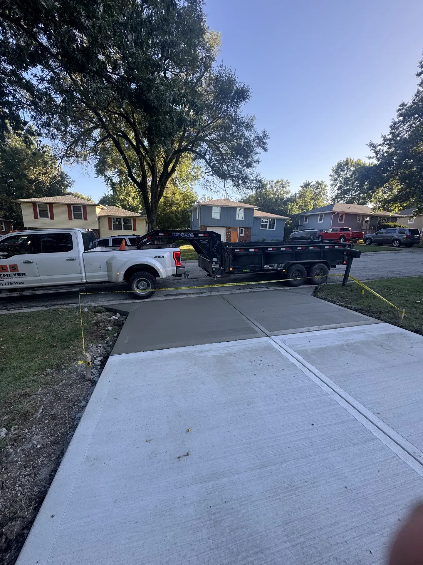 Jostmeyer Land Solutions branded truck parked on completed concrete driveway