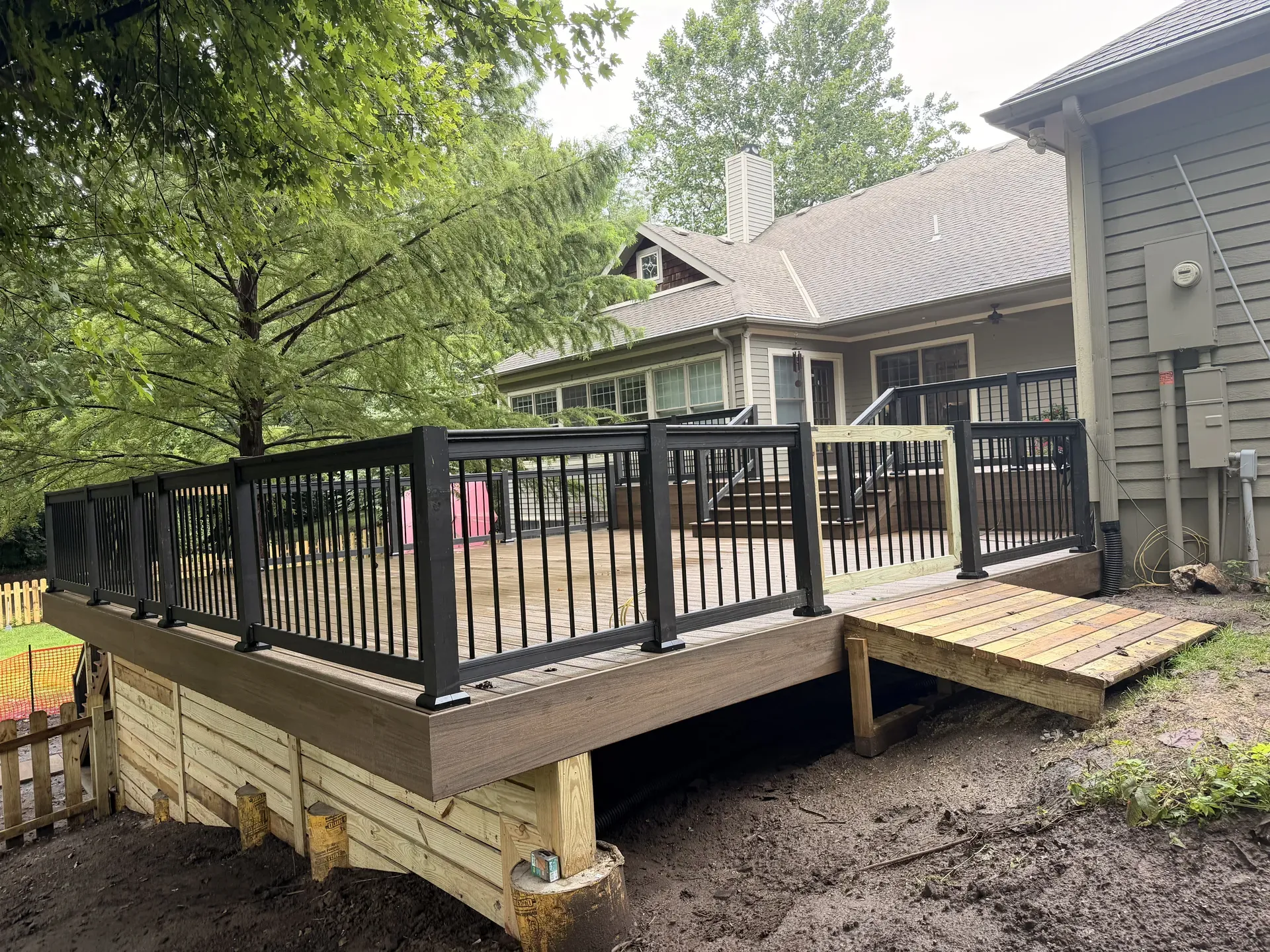 Large composite deck with black aluminum railing — full backyard view