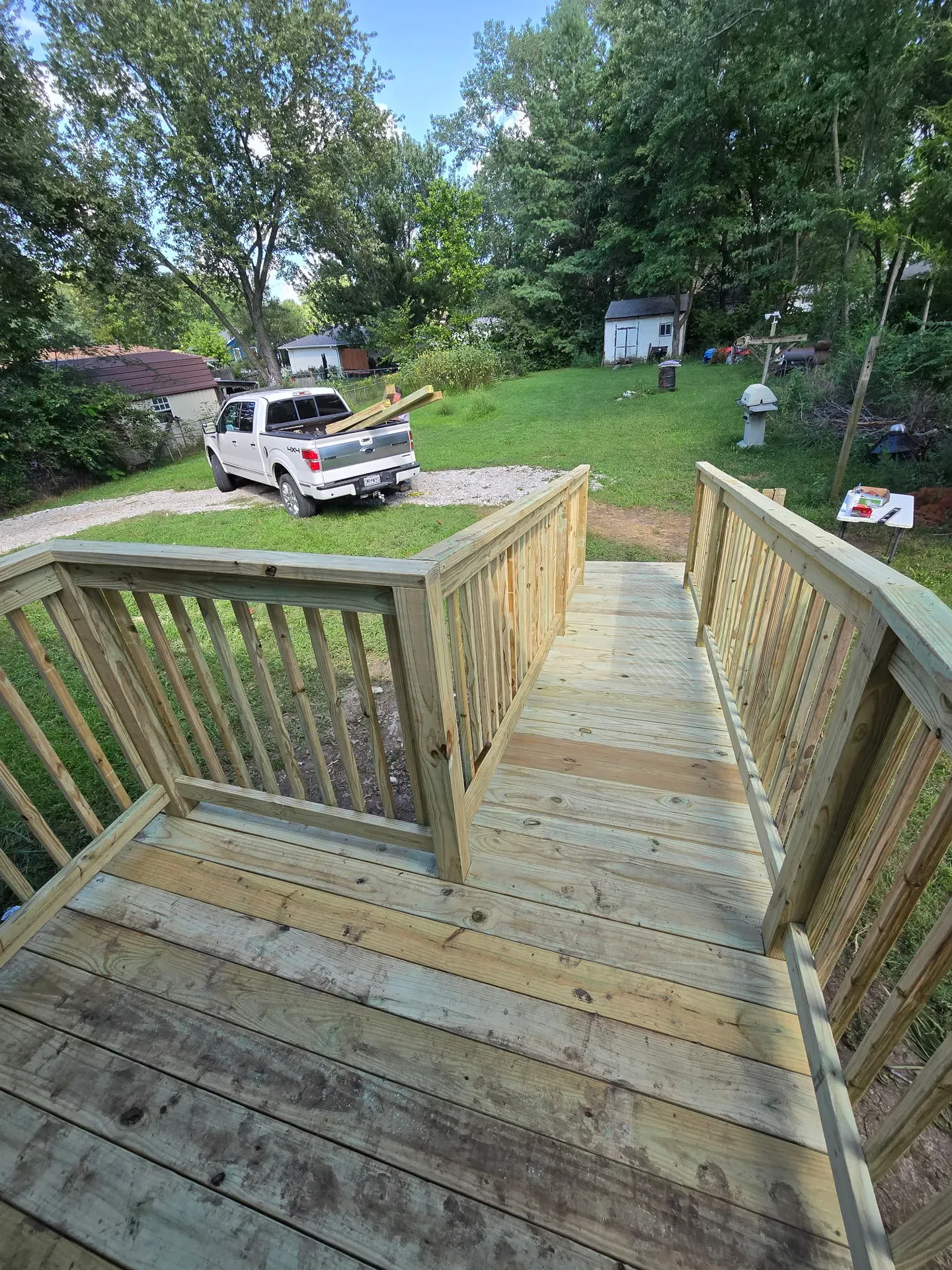 Completed deck with dual staircase access and open backyard