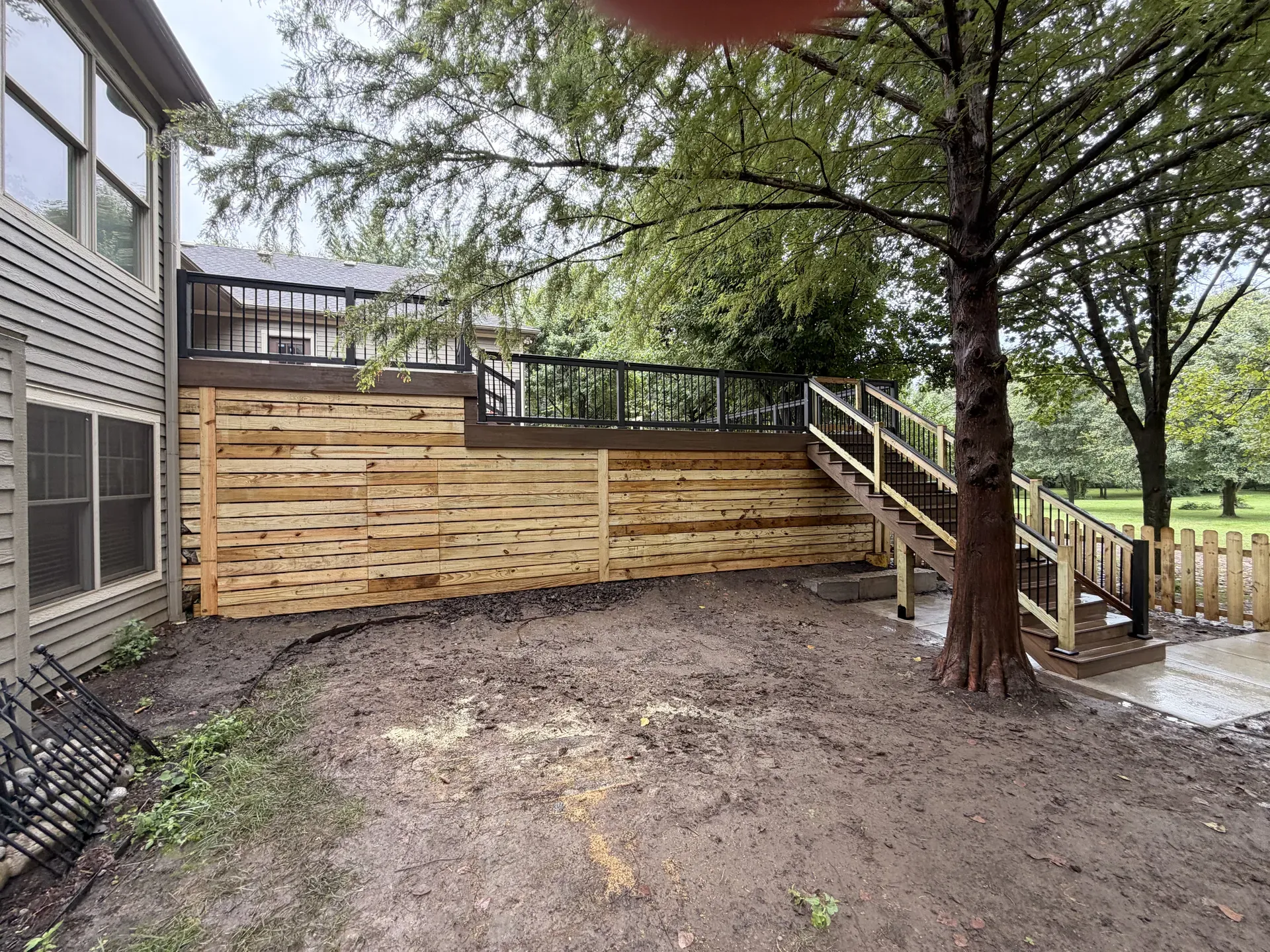Deck with horizontal wood skirting panels, wide backyard view