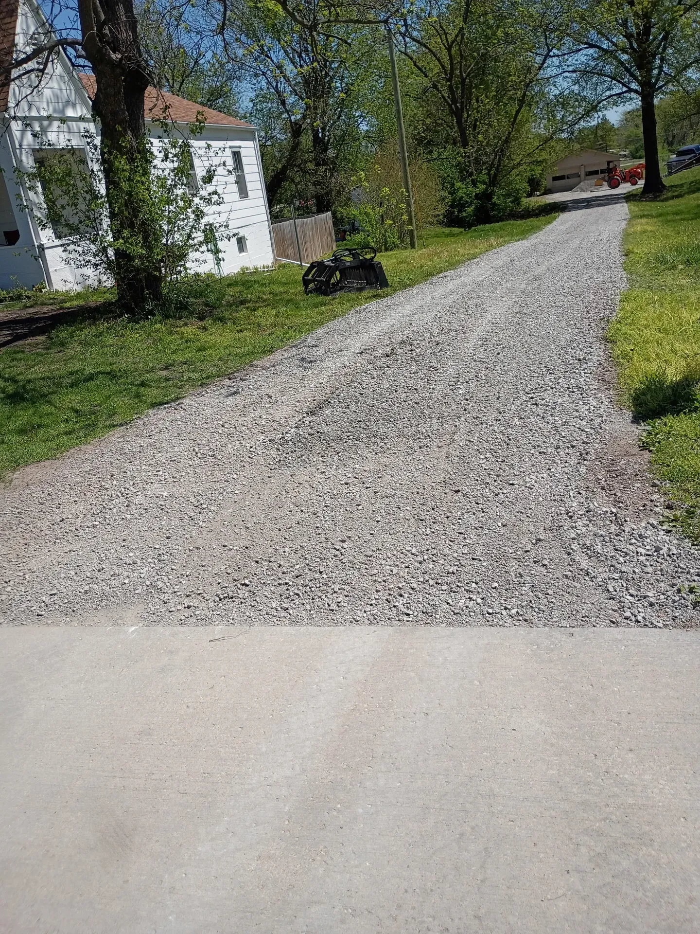 Gravel driveway with stone wall feature at entry