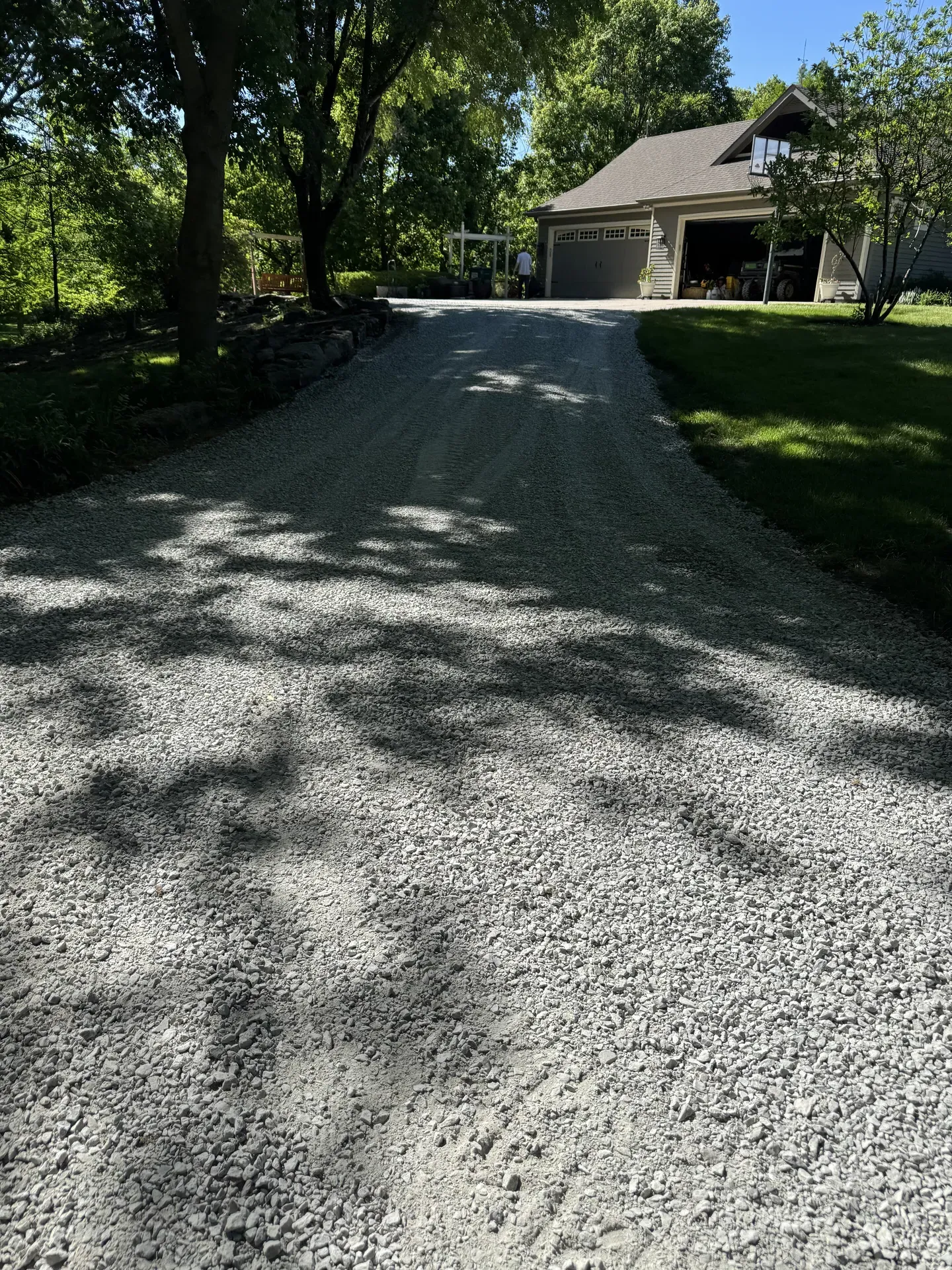 Tree-lined gravel driveway installed by Jostmeyer Land Solutions in Clay County Missouri