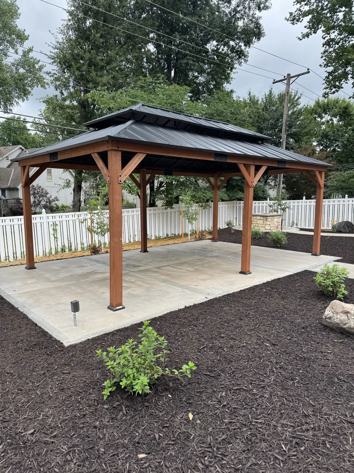 Outdoor gazebo with standing seam metal roof and landscaping