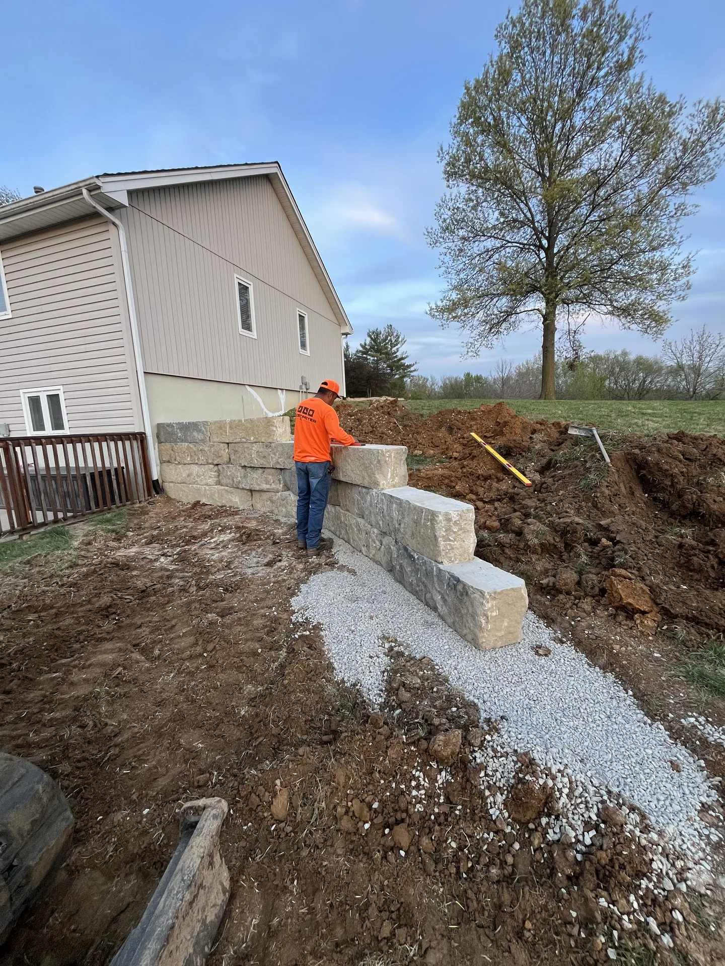 Crew installing retaining wall with gravel base