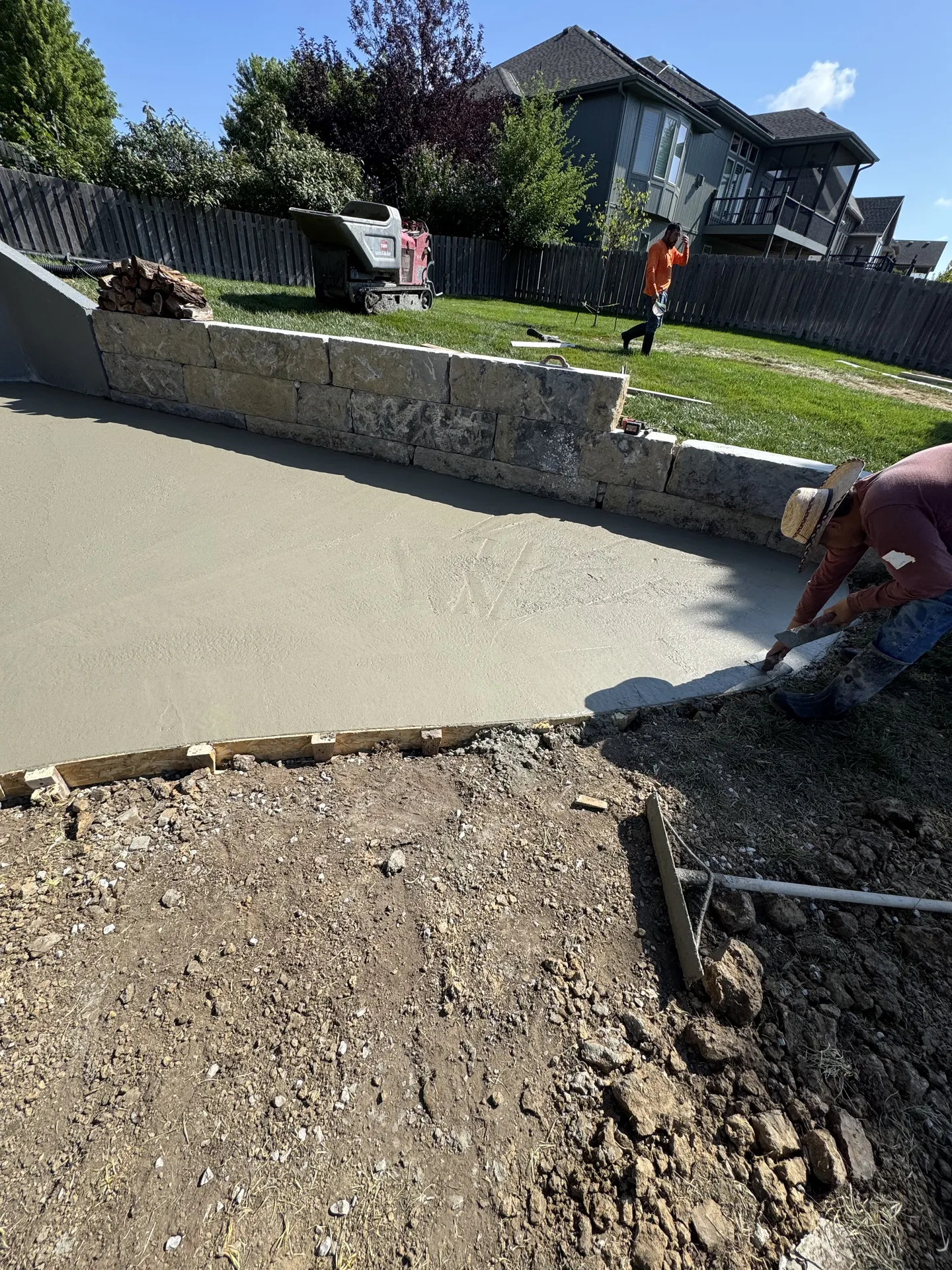 Worker and equipment at retaining wall construction