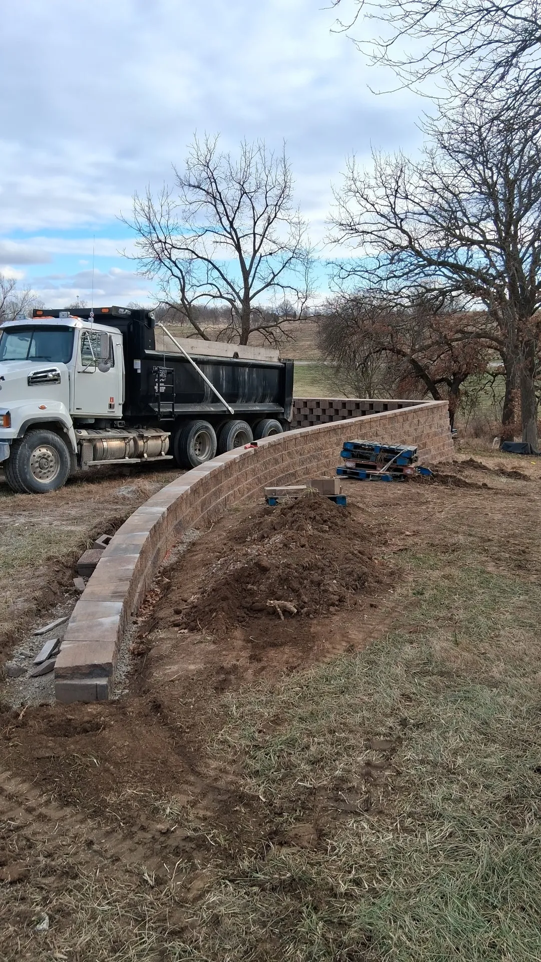 Curved retaining wall with construction truck on site