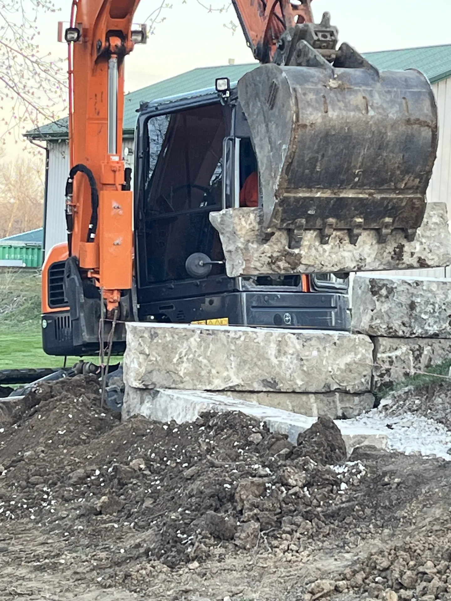 Excavator at retaining wall construction site