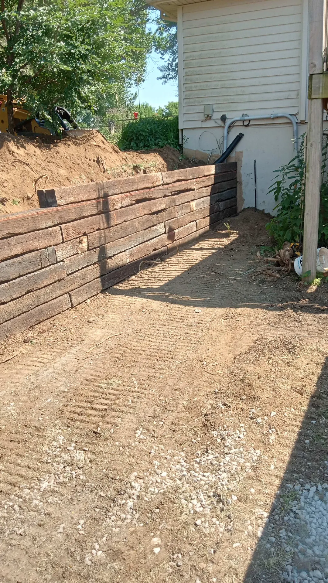 Timber retaining wall along side of house